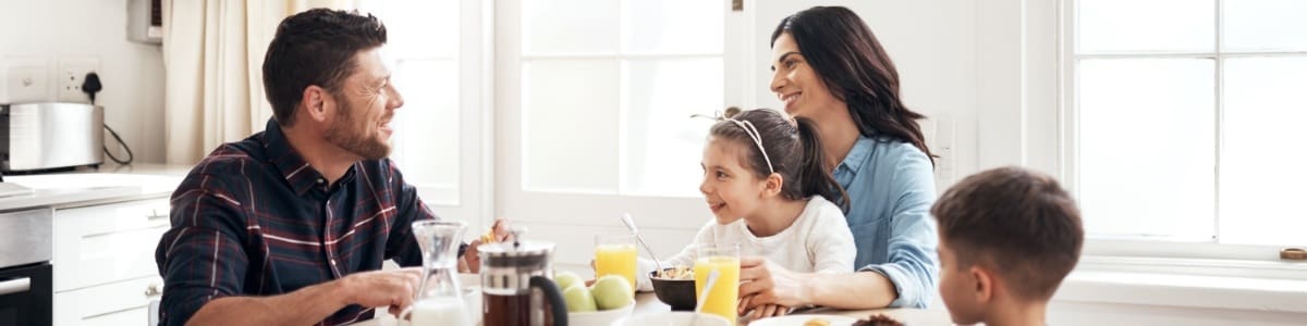 cute family of 4 eatting breakfast at dinning table